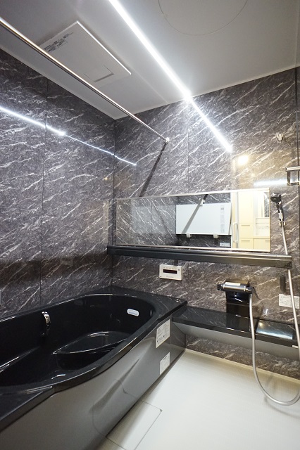 ブラックの浴槽と大理石調壁パネル、天井のフラットラインLED照明が高級感のある浴室を演出 アイキャッチ ブラックの浴槽と大理石調壁パネル、天井のフラットラインLED照明が高級感のある浴室を演出 アイキャッチ